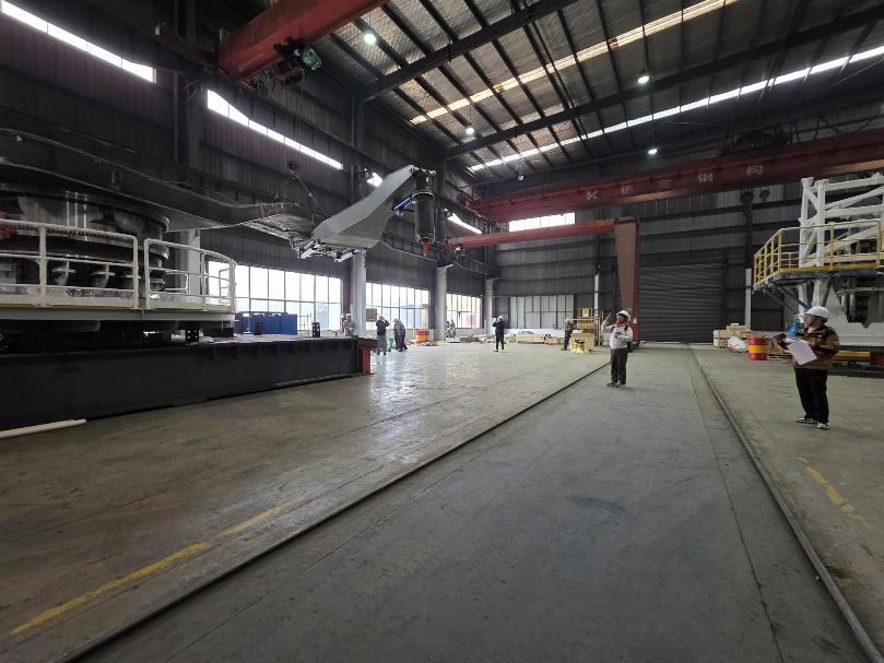 Spooling arm assembly — overhead crane lift inside fabrication shop