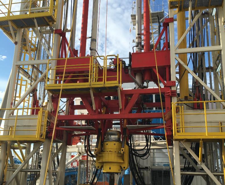 Drill string heave compensator close-up — red structure with twin yellow cylinders