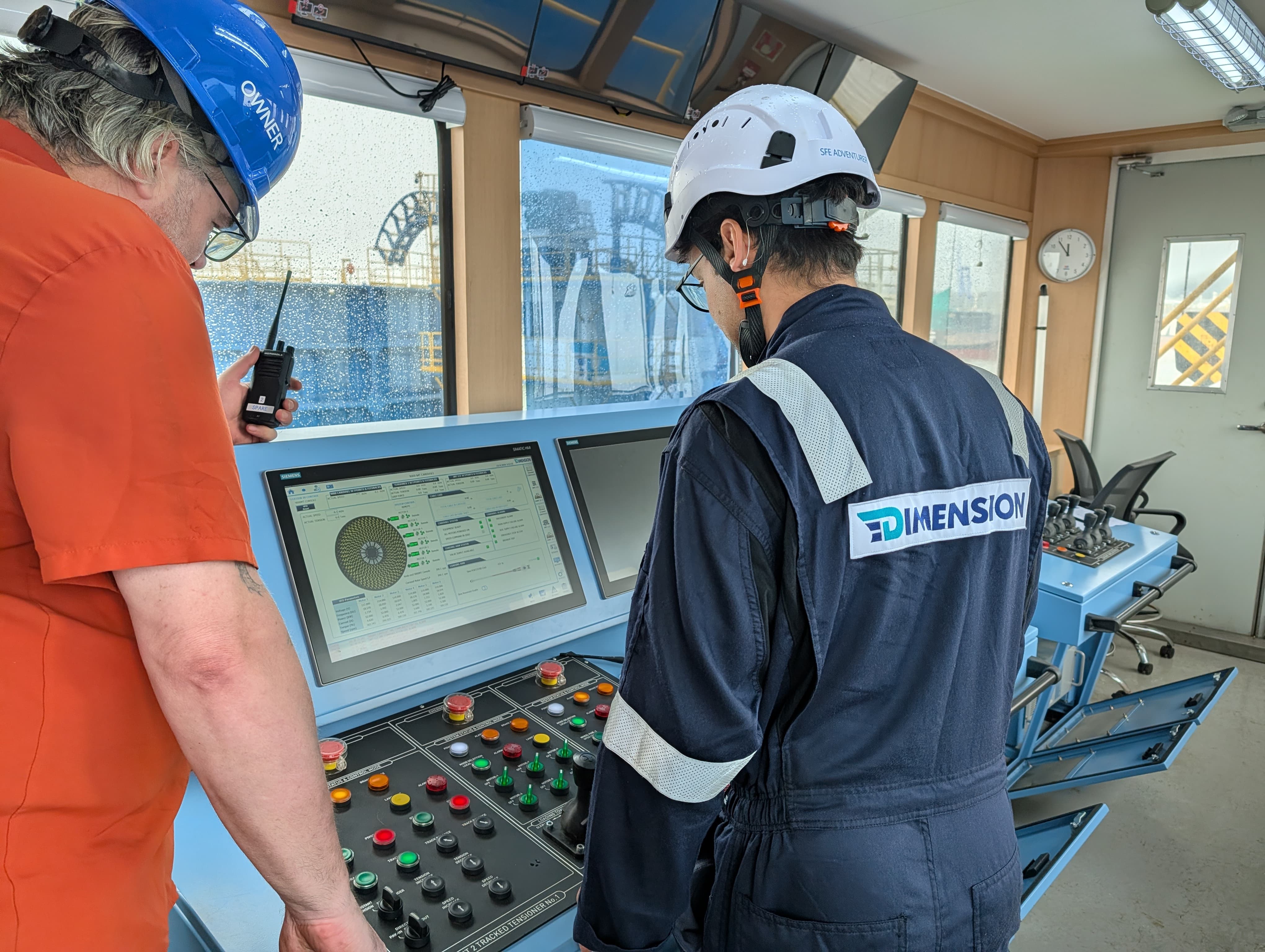 Dimension engineer at the HMI control console — live carousel rotation diagram and tension readout, with operator on radio